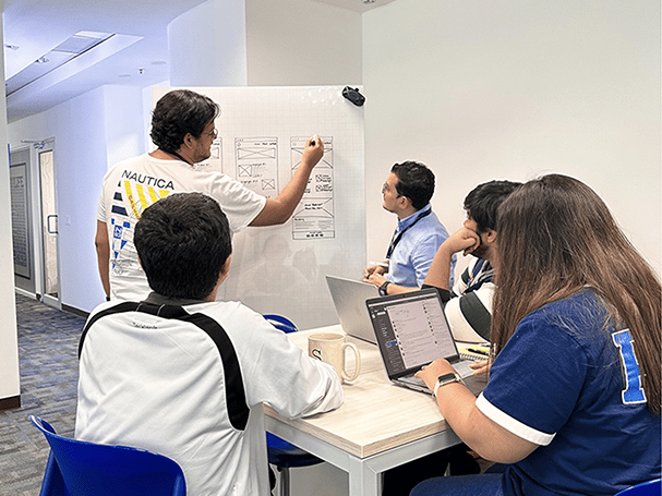 coworkers sitting on tall table working on wireframes