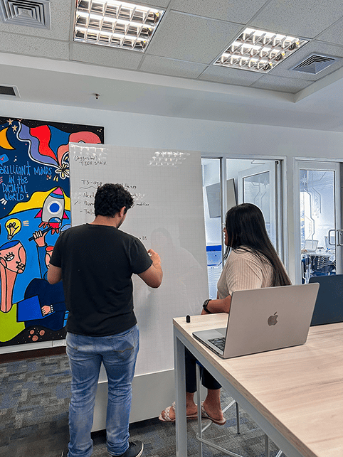 coworkers collaborating on the whiteboard at the office