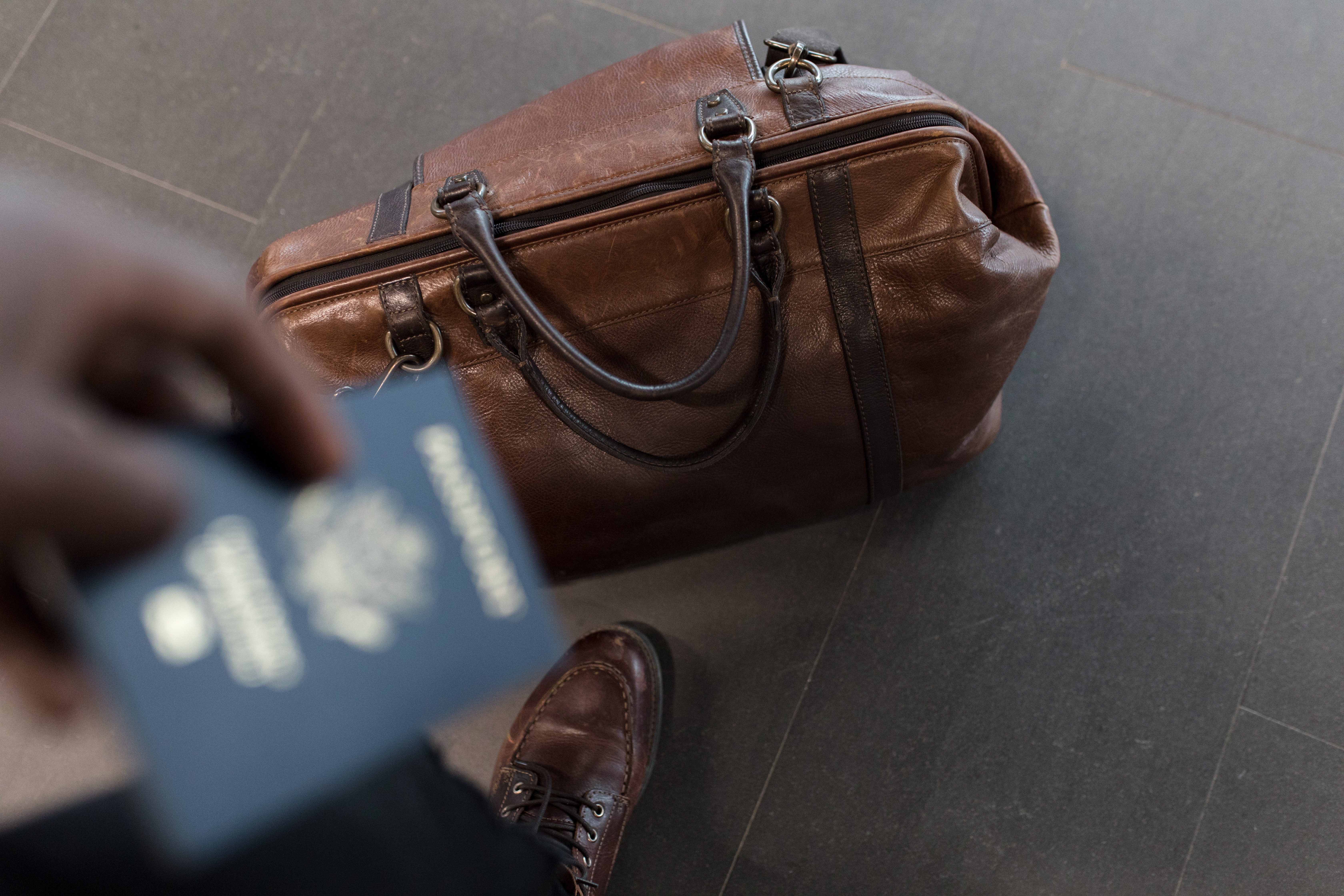 bag-on-floor-and-passport-in-hand